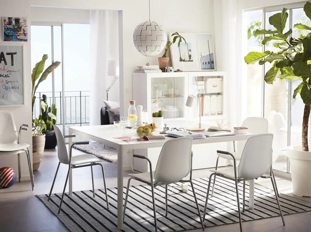 Bright Scandinavian dining room with white chairs and plants