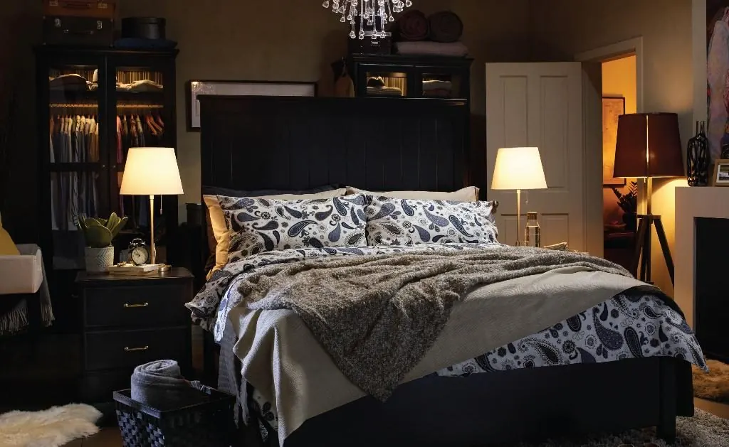 Dark moody bedroom lit by lamps